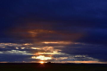 Gloomy autumn sunset against the backdrop of heavy clouds