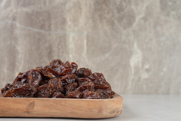 Dried brown plums on a wooden platter