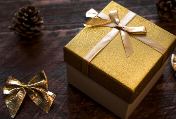 Fototapeta na wymiar Closeup of shiny little golden box with present for christmas ir new year. 2023