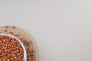 Brown beans in a ceramic plate on concrete background