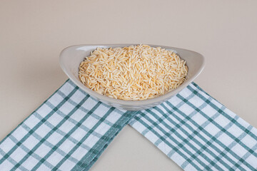 Yellow rice in ceramic cups on concrete background