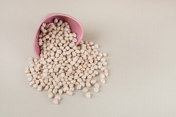 White raw pea beans in a metallic cup on concrete background