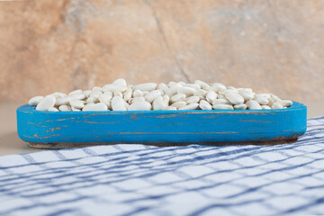 White beans on a platter on concrete background
