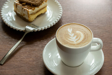 Cappuccino or latte with frothy foam, coffee cup top view on wooden background. Cafe and bar, barista art concept.