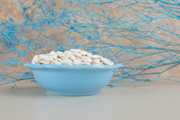 White beans in a cup or bowl on concrete background