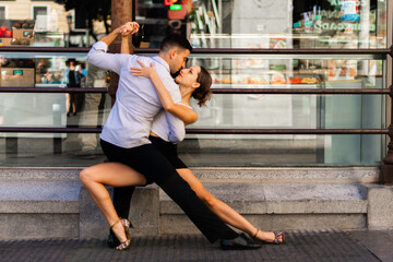 Tango dancing couple. Boy in a suit and shirt, girl in shorts and a t-shirt. dance, street, argentinian - obrazy, fototapety, plakaty