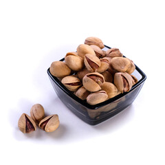 Salted pistachios in glass bowl isolated on white background