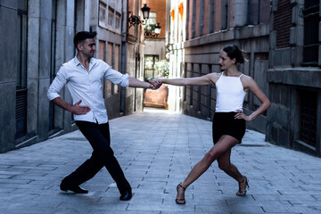 Tango dancing couple. Boy in a suit and shirt, girl in shorts and a t-shirt. dance, street,...