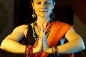 Close up portraite of yoga woman in Indian sari. Hands in namaste gesture.