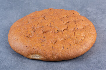 Round loaf of bread on marble background
