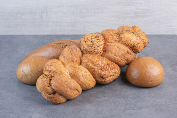 Fototapeta na wymiar Loaves of baton strucia and bun bread bundled on marble background