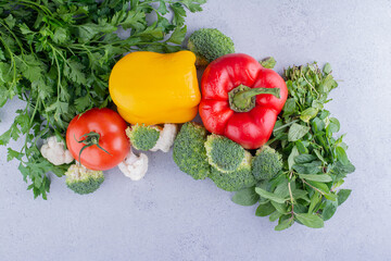 Arrangement of vegetables and greens on marble background