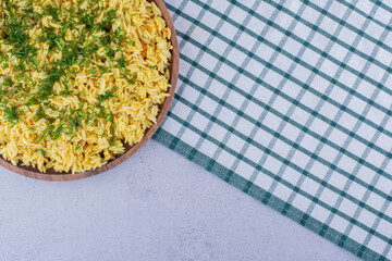 Large tray of cooked brown rice topped with dill on marble background