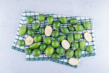 Feijoas on a folded tablecloth on marble background
