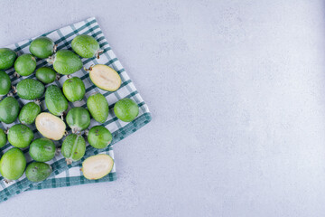 Delectable feijoas on a folded tablecloth on marble background