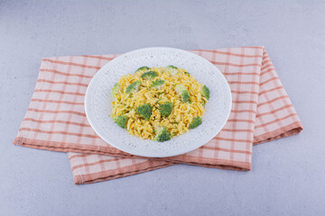 Brown rice pilaf with broccoli topping on marble background