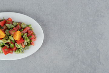 Red cherry tomato and beans salad in a ceramic plate