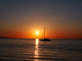 Sunset behind a catamaran in the Aegean Sea  - obrazy, fototapety, plakaty