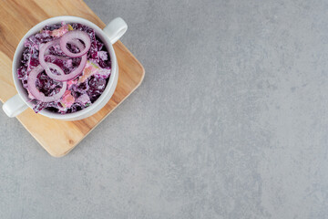 Purple cabbage and onion salad with various ingredients in ceramic cups