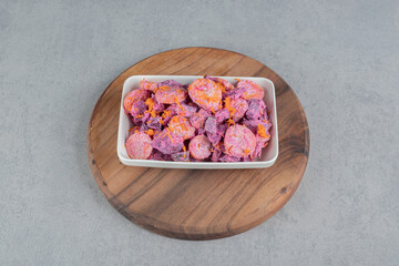 Vegetable salad with purple beetroots and orange chopped carrots mixed with sour cream