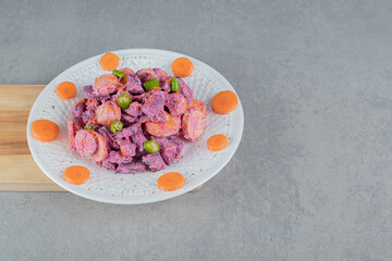 Vegetable salad with purple beetroots and orange chopped carrots mixed with sour cream