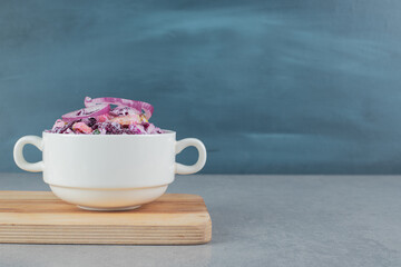 Chopped purple onion and cabbage salad in ceramic cups