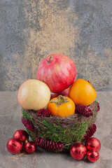 Decorated bowl with a pile of fruits on marble background