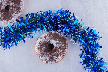 Two donuts and a line of garland in the middle on white background
