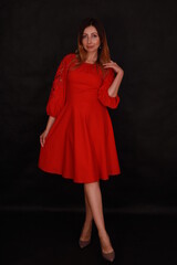 Beautiful woman in red dress on black background