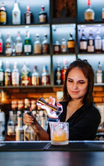 Portrait of young attractive woman bartender Making Cocktail in bar