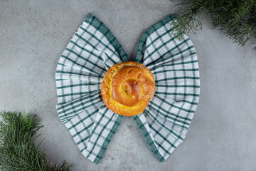 Obraz premium Bun and towel in a bow tie arrangement on marble background
