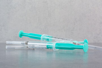 Three syringes with serum on marble surface