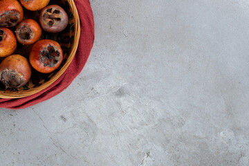 Obraz na płótnie Canvas Basket of kakis with seeds removed on marble background