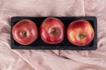 Apples on a tray on textile background