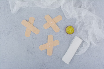 Band aid plaster strips, bandage and vaseline on marble surface