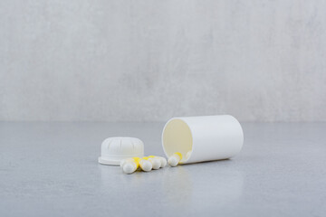 Fototapeta na wymiar Pharmaceutical capsules out of plastic white container