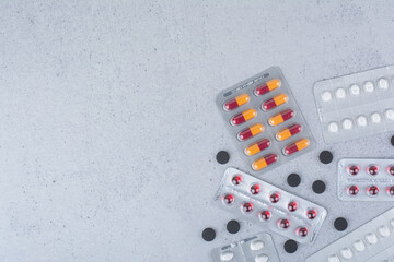 Variety of pills and capsules on marble surface