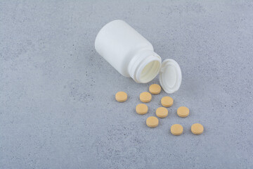 Pharmaceutical pills out of plastic white container