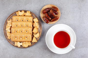 A wooden cutting board of gohal and dates on marble background