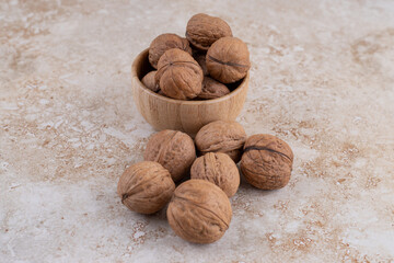 A small wooden bowl full of healthy walnuts