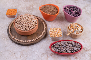 Delicious lentils and beans in plates on marble background