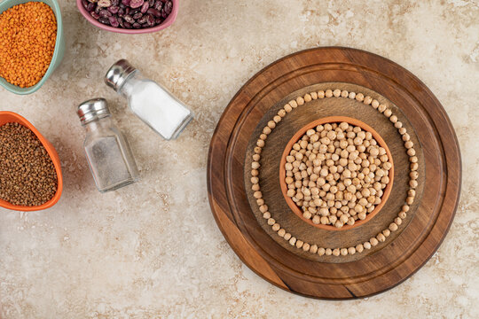 A Wooden Bowl Full Of Unprepared Peas With Spices And Beans