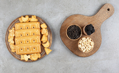 A wooden board full of biscuits on marble background