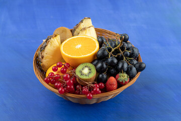 A wicker basket full of fruits on blue background