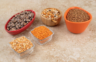 Delicious lentils and beans in plates on marble background