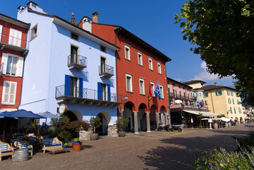 Fototapeta na wymiar Red town hall at village of Ascona, Canton Ticino, with colorful houses on a sunny summer day. Photo taken July 24th, 2022, Ascona, Switzerland.