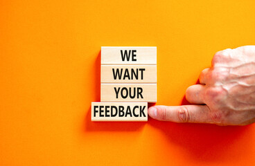 Support and we want your feedback symbol. Concept words We want your feedback on wooden blocks on beautiful orange background. Businessman hand. Business, support we want your feedback concept.