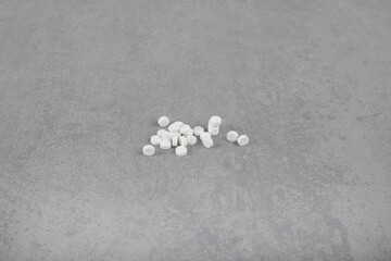 Fototapeta na wymiar A lot of white circle pills on gray background