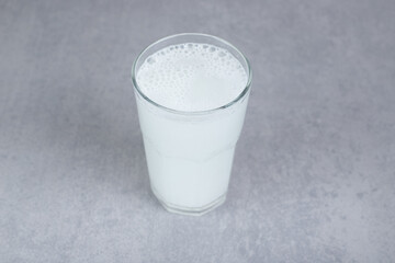 A glass of pure cold water on gray background