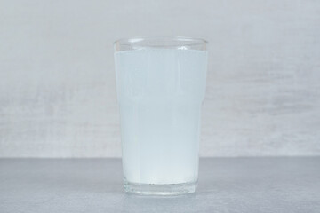A glass of pure cold water on gray background